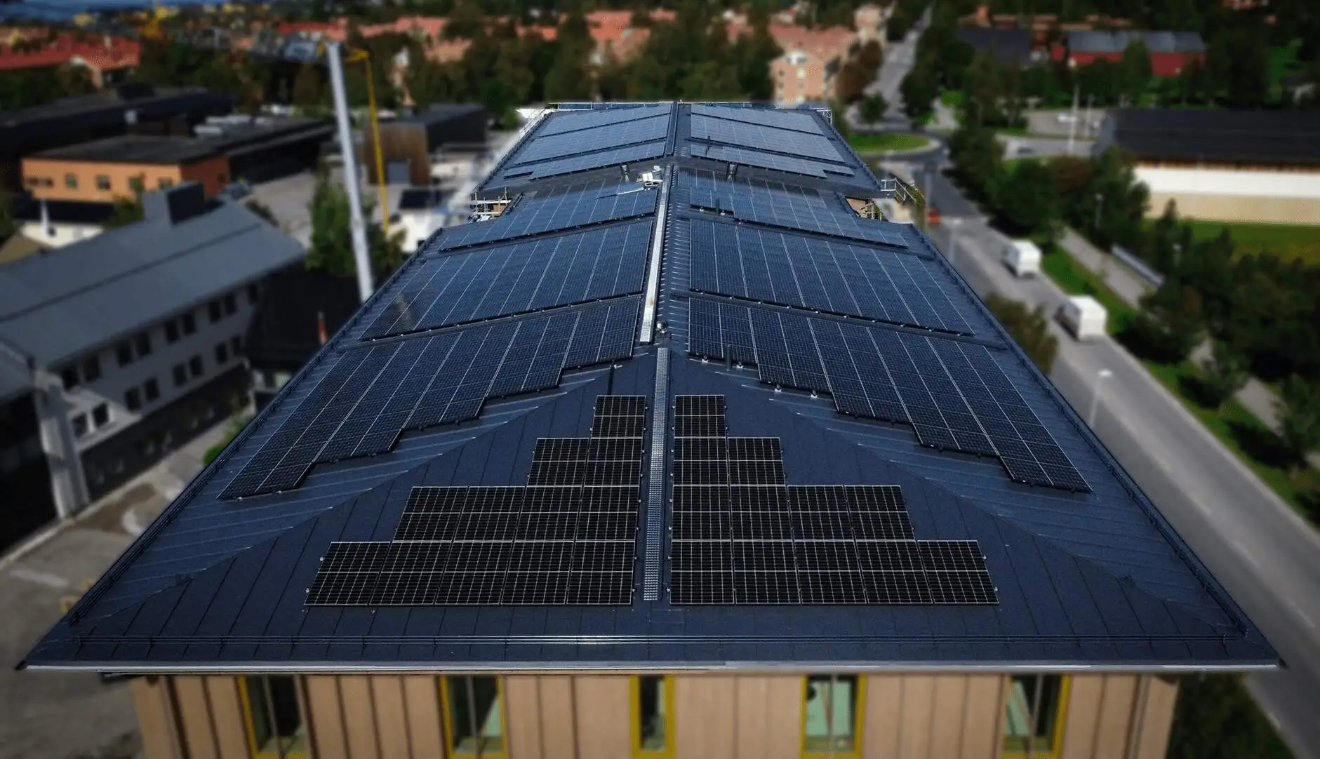 Stort tak med installerade solpaneler på kommersiell byggnad i stadsmiljö